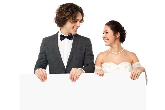 Newly wed couple posing with a blank white board