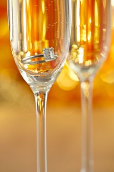 Champagne glasses with engagement Jewelry in front of autumn background