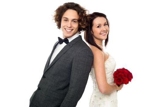 Bride and groom leaning on each other, back to back