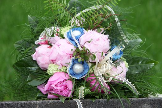 Pink and blue wedding bouquet on the curbside in the grass