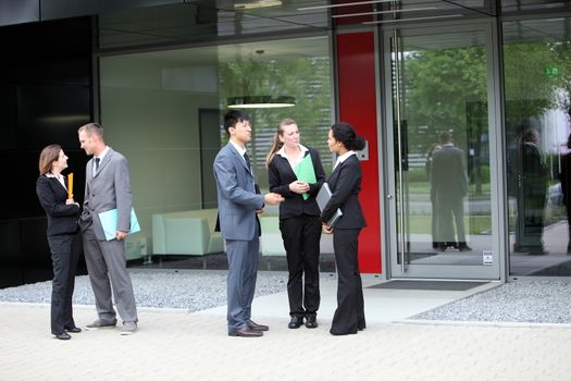 A group of businesspersons talking with two business couple on the side