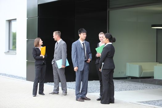 A group of Professional businesspeople talking in the lobby of office building