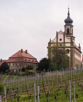 Evangelical Lutheran church of St Johannis or Johannes in small Bavarian village of Castell in Germany. Church rises above trees from surrounding vineyards of Castell winery.
