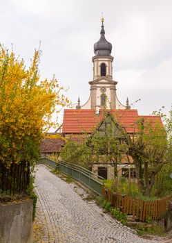 Evangelical Lutheran church of St Johannis or Johannes in small Bavarian village of Castell in Germany. Church rises above trees from surrounding vineyards of Castell winery.
