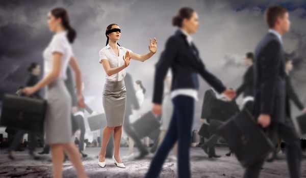 Image of businesswoman in blindfold walking among group of people