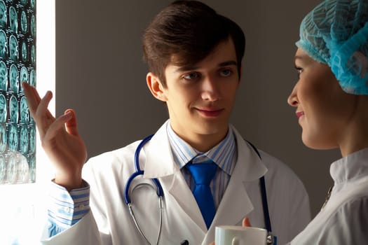 Image of two young two doctors discussing x-ray results