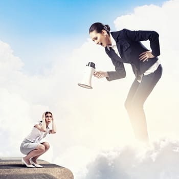 Angry businesswoman with megaphone shouting at colleague