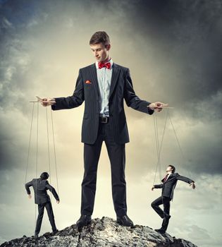 Image of young businessman puppeteer. Leadership concept