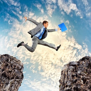 Image of young businessman jumping over gap