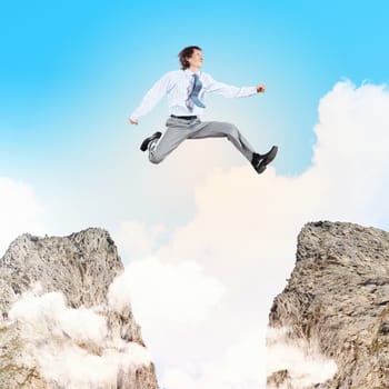 Image of young businessman jumping over gap