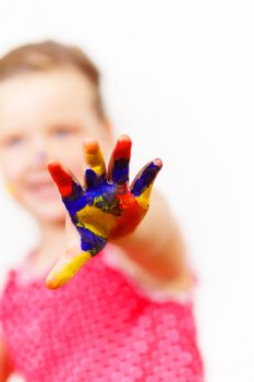 little child with hands painted in colorful paints ready for hand prints