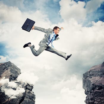 Image of young businessman jumping over gap