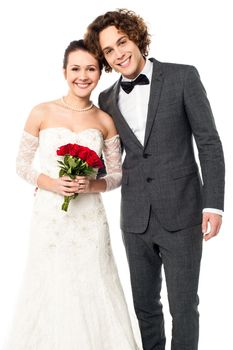 Handsome young groom leaning against bride and smiling warmly. Newlywed couple