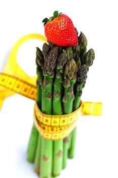 strawberry, asparagus tied with measuring tape isolated on white