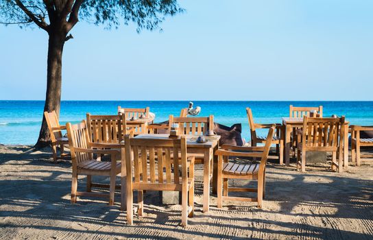 Cafe on a tropical beach with blue sea on background