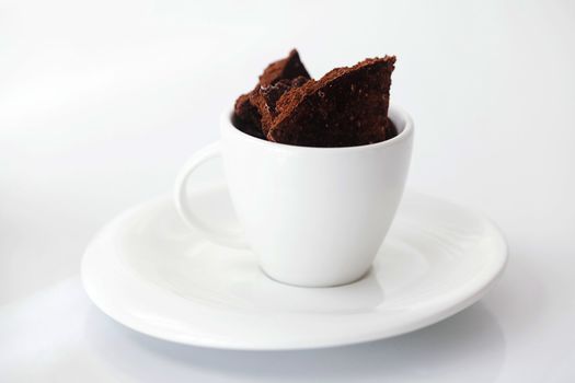 white cup with saucer and chocolate 