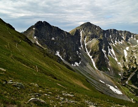 Spring background with mountain ridge the slopes with the snow