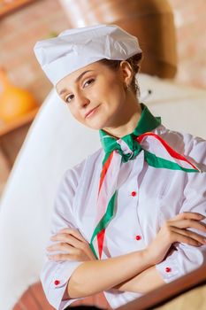Image of young woman cook standing at kitchen