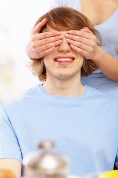 Young couple at home together - closing partner's eyes