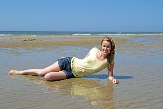 Beautiful blonde woman relaxing in the water from the north sea in the Netherlands