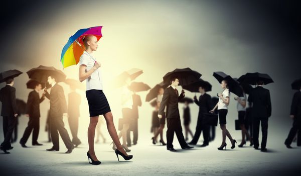 Image of pretty businesswoman with umbrella walking in crowd of people