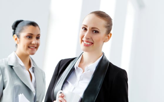 Image of two young pretty businesswomen smiling