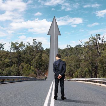Concept of the road to success with a businessman standing on the road