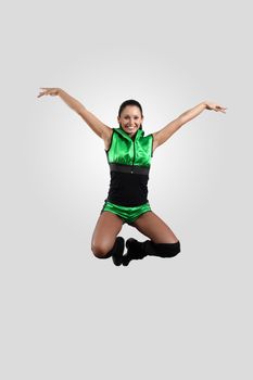 Young female dancer jumping against white background