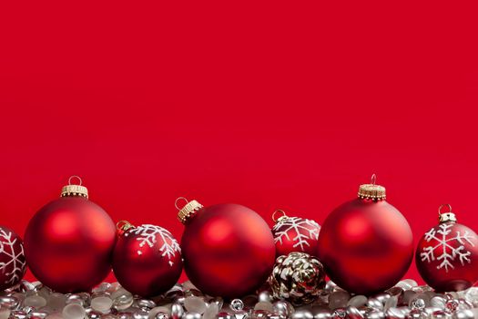 Red and silver Christmas decorations on crimson background