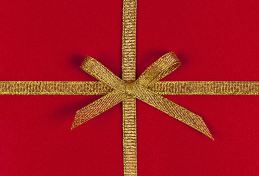 Red present wrapped with gold ribbon and bow