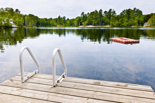 Dock and ladder on summer lake with diving platform in Ontario Canada