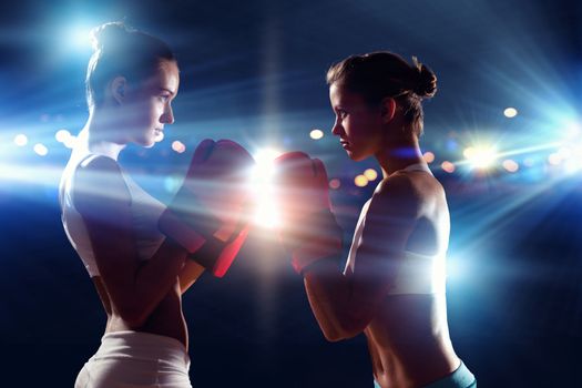 Two boxer women in gloves greet each other before fight