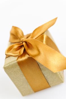 Gift box in gold wrapping paper with ribbon and bow