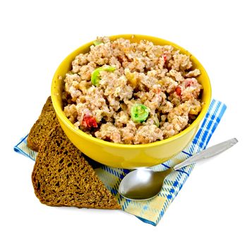 Porridge rye flakes with candied fruits in a yellow bowl, rye bread, spoon on blue napkin isolated on white background