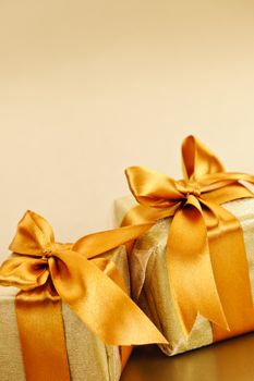 Two gift boxes wrapped in gold ribbons with copy space