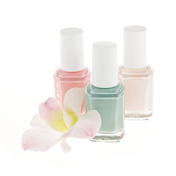 Three nail polish bottles with orchid flower on white background