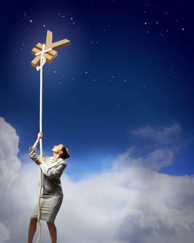 Image of businesswoman climbing the rope attached to yen sign