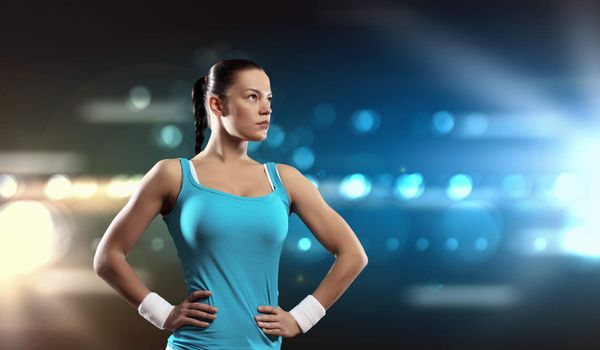 Image of sportswoman exercising against lights background