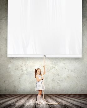 Little pretty girl pulling blank banner. Place for text