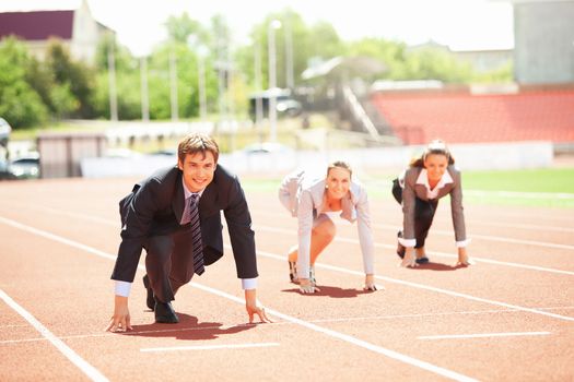 Businessmen running on track racing at athletich stadium