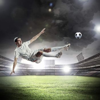 football player in white shirt striking the ball at the stadium