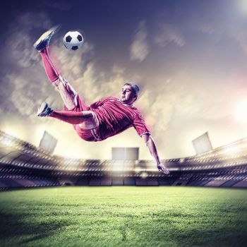 football player in red shirt striking the ball at the stadium