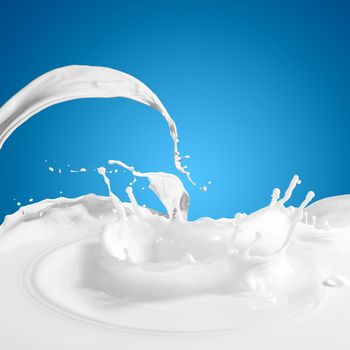 Pouring white milk splash on colour background