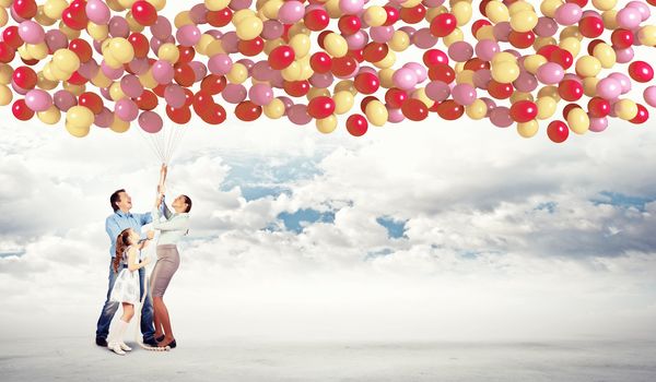 Image of happy family holding bunch colorful balloons