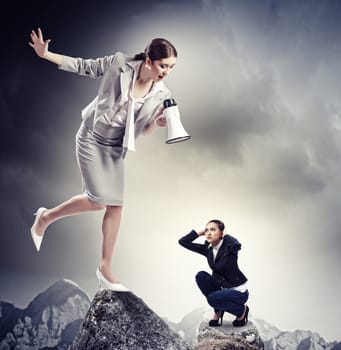 Angry businesswoman with megaphone shouting at colleague