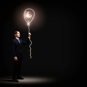 Image of businessman in black suit against dark background