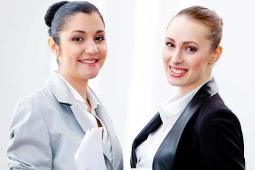 Image of two young pretty businesswomen smiling