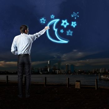 Businessman draws a variety of signs on the dark sky