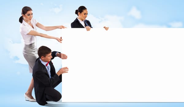 Image of three young people holding blank banner against blue background. Place for text