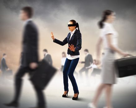 Image of businesswoman in blindfold walking among group of people